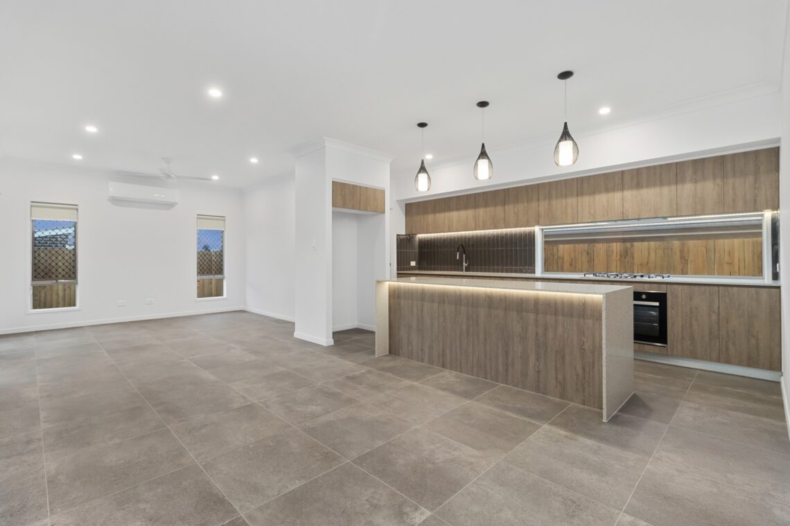 Modern open-plan living room and kitchen with a splashback window